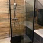 Salle de bain moderne, entièrement rénovée. Présentant une douche et une baignoire.